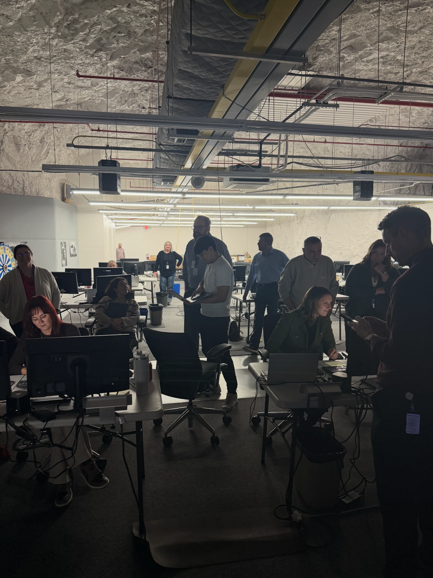 Staff and engineers gathered around workstations in the underground retirement operations center