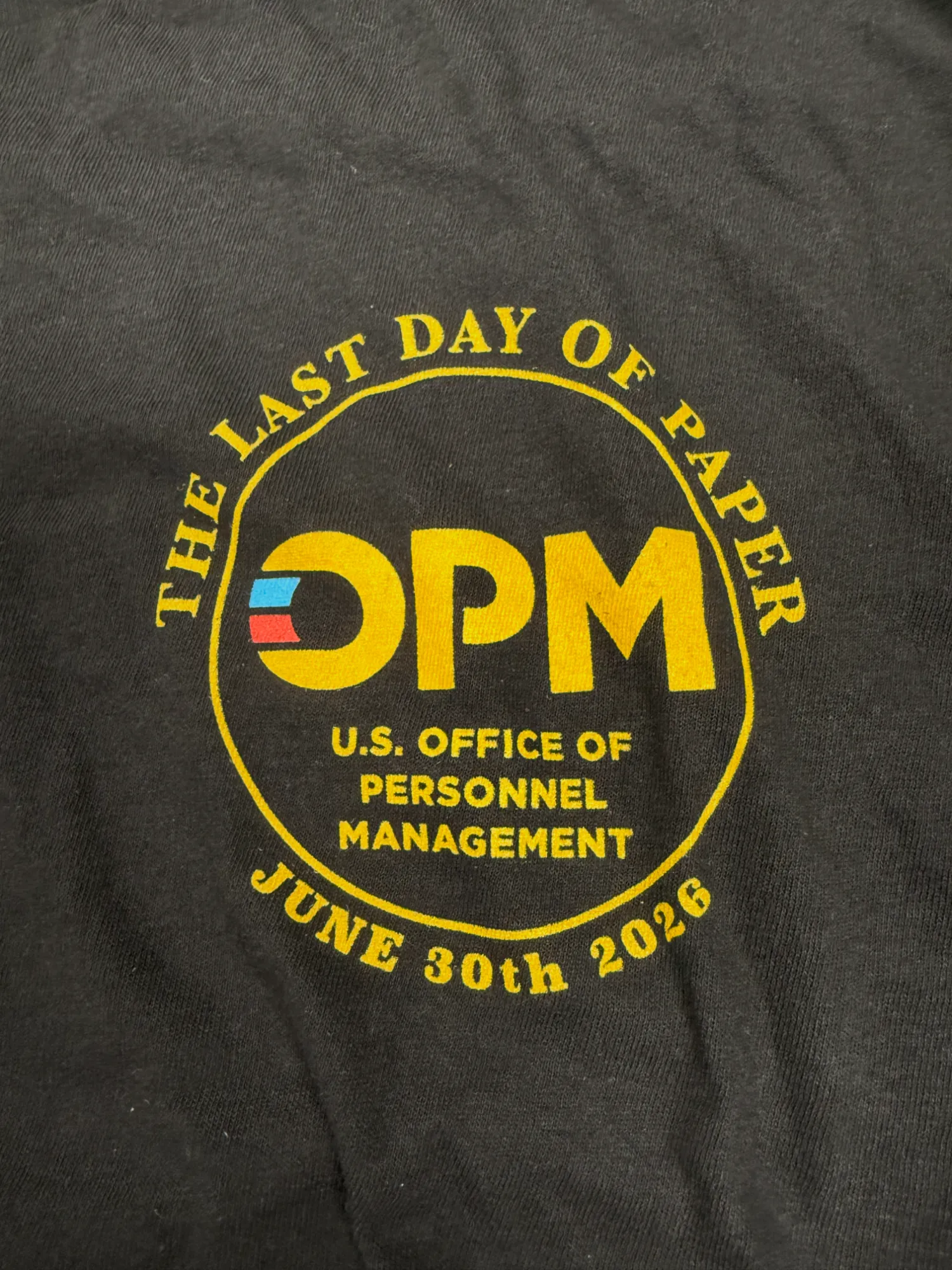 Shirt print reading “The Last Day of Paper, U.S. Office of Personnel Management, June 30th 2026”